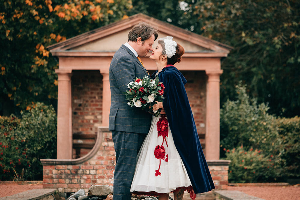 Couple standing in front of an arch getting married