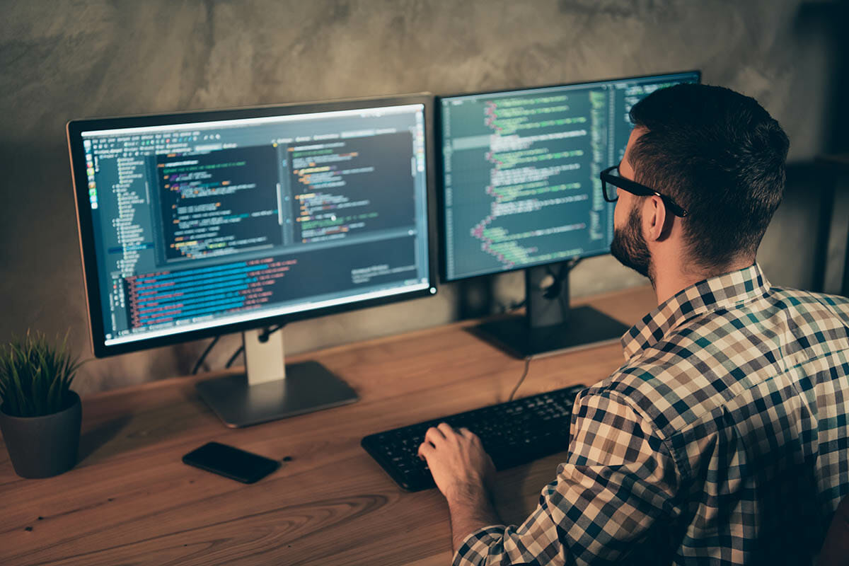 Profile side view of his he nice bearded guy wearing checked shirt professional expert html data base structure screen at wooden industrial interior work place station