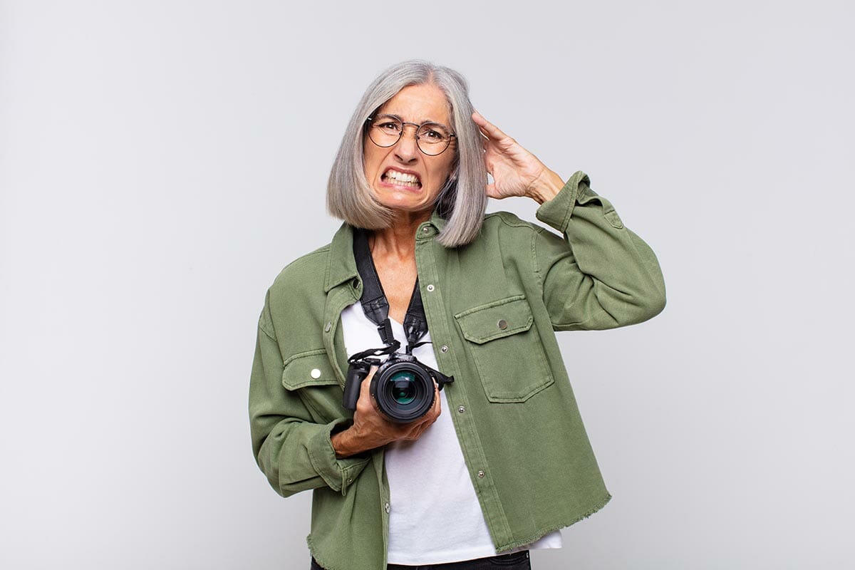 middle age woman feeling stressed, worried, anxious or scared, with hands on head, panicking at mistake. photographer concept