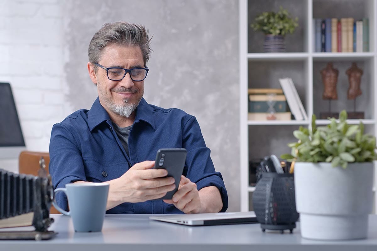 Bearded,Man,Working,Online,With,Laptop,Computer,And,Smart,Phone
