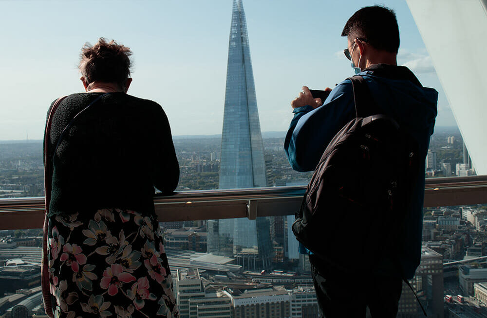 A man talking a photo from the Walkie Talkie Building in London looking at the Shard