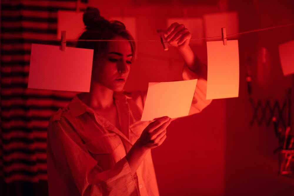 hobbyist or professional photographer. Young girl developing photos in a dark room. Retro style photography