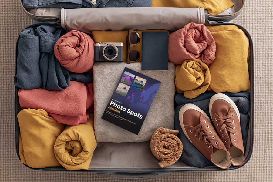 The Photo Spots book packed in a suitcase with a camera, ready for a trip.